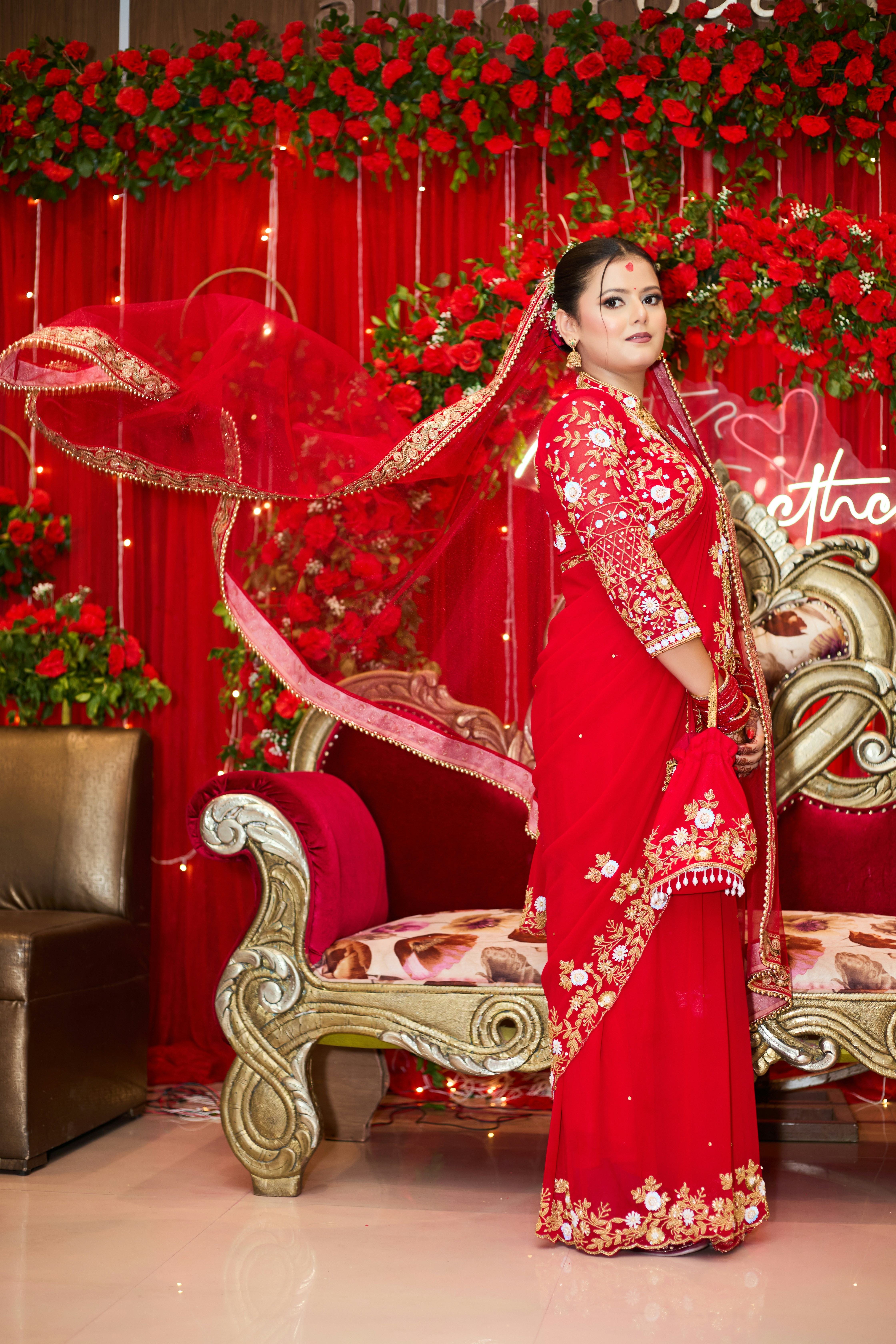 A woman in a red sari posing for a picture