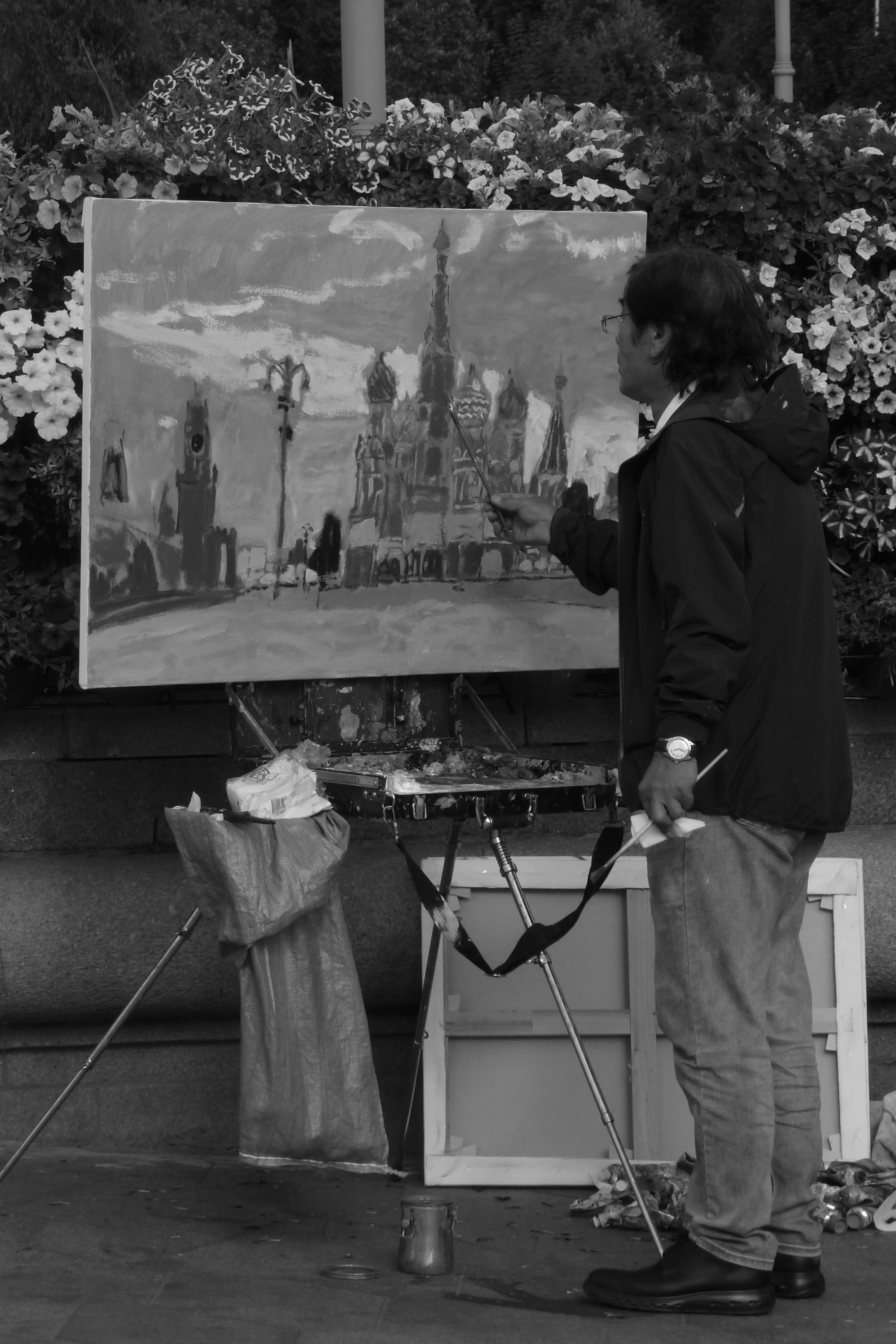 A man standing next to a painting on a easel