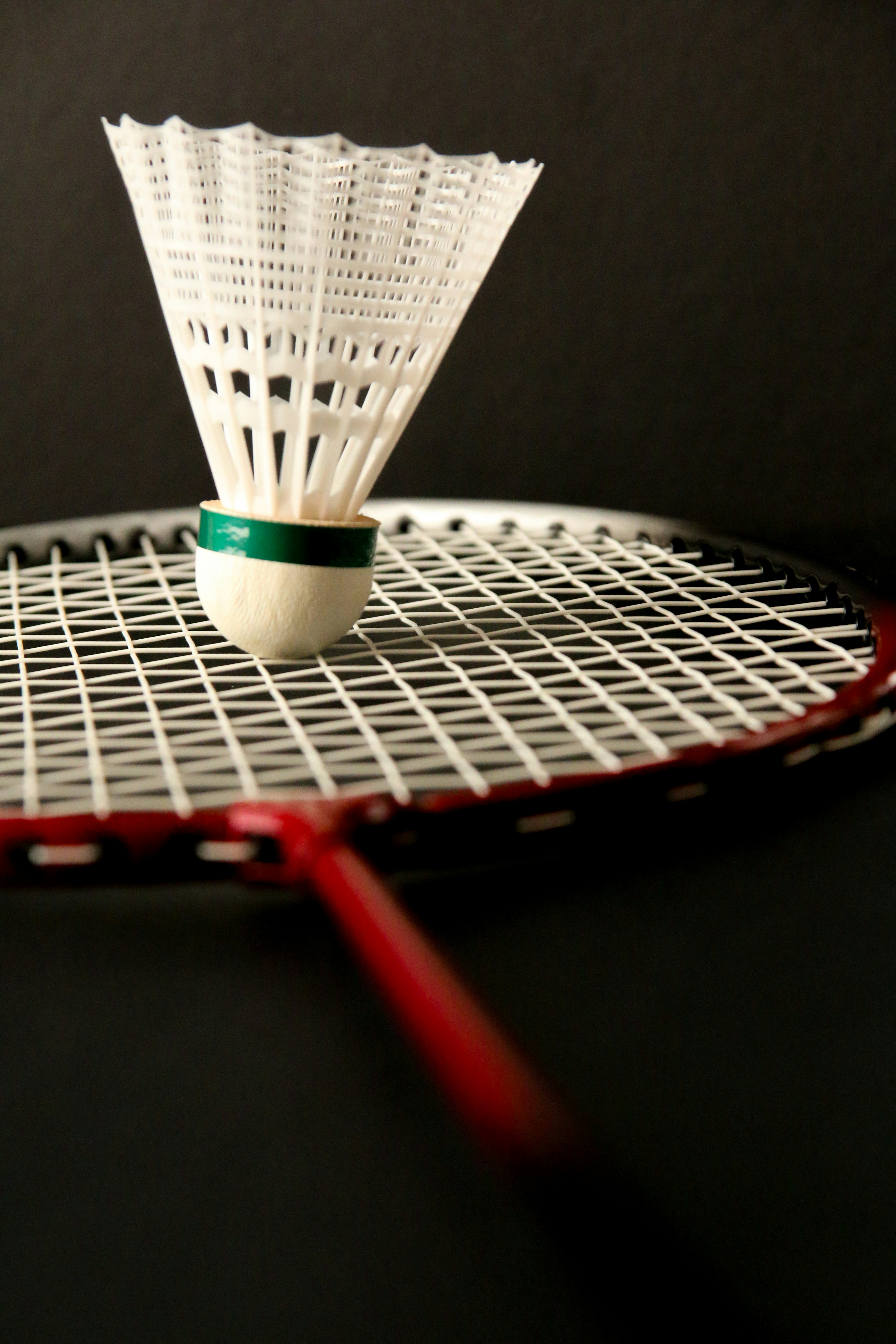 A badminton racket with a ball on top of it