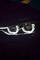 A close up of a car's headlight in the dark