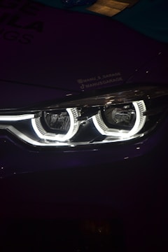 A close up of a car's headlight in the dark
