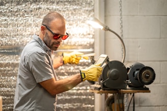 A man in a gray shirt and yellow gloves