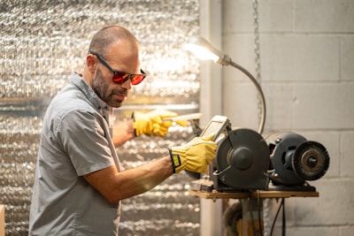 A man in a gray shirt and yellow gloves