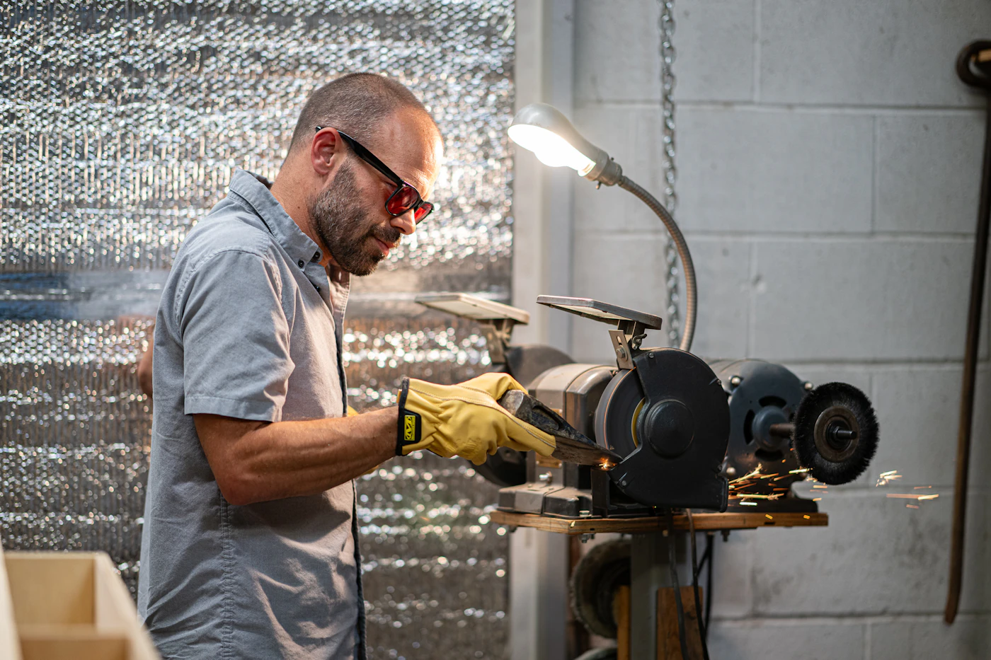 Worker's hands operating machinery in a factory, showing the need for hand protection