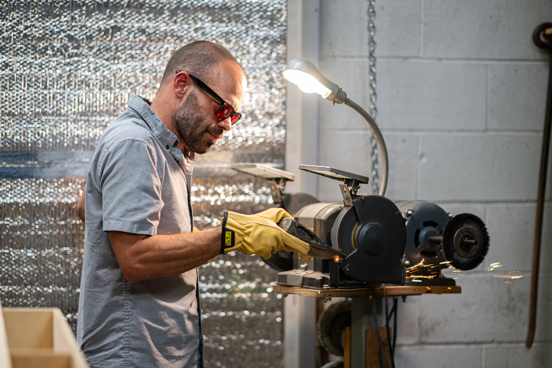 Handwerker mit Schutzbrille beim Schleifen in der Werkstatt – EyeGenius Augenschutz von Optik Sauter