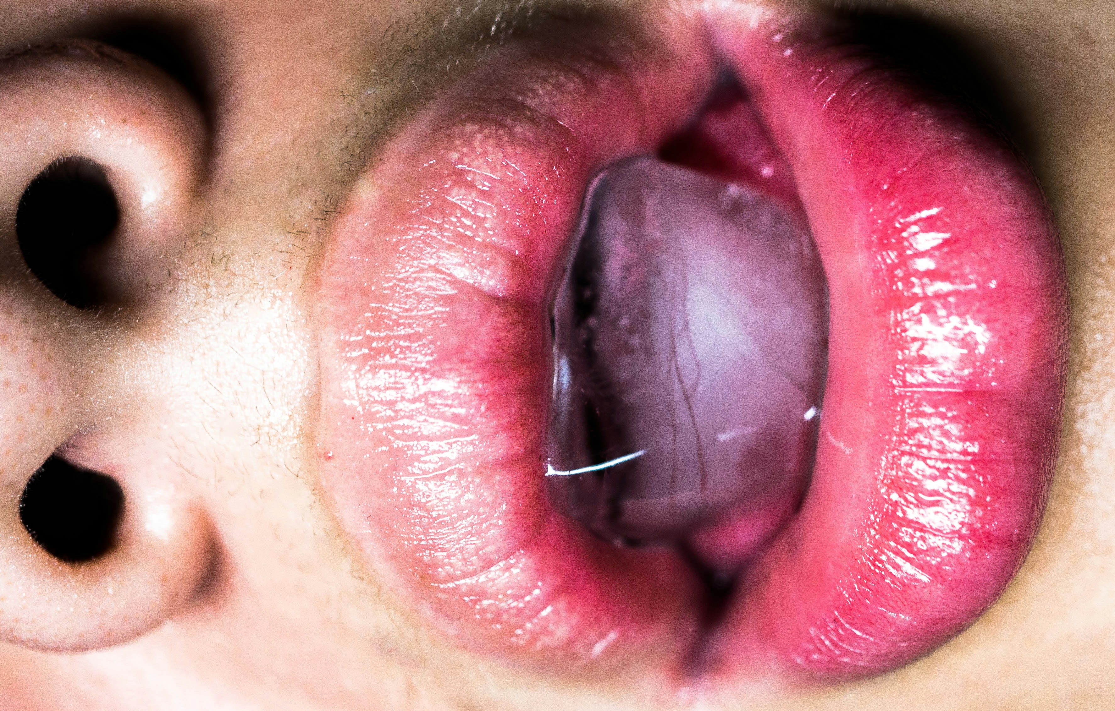 A close up of a person's tongue with a piece of food in the