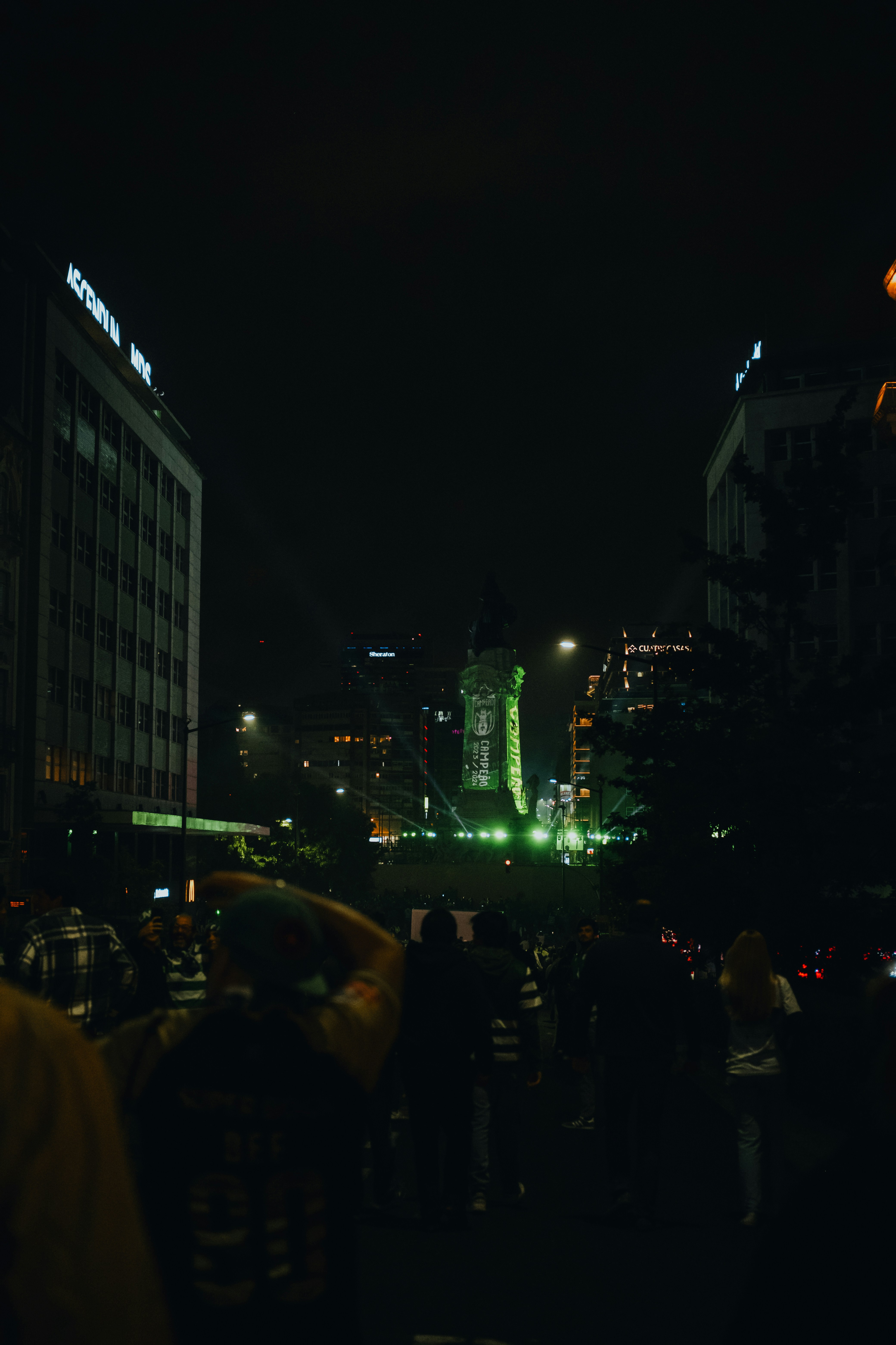 Eine Menschenmenge, die nachts in einer Stadt herumsteht