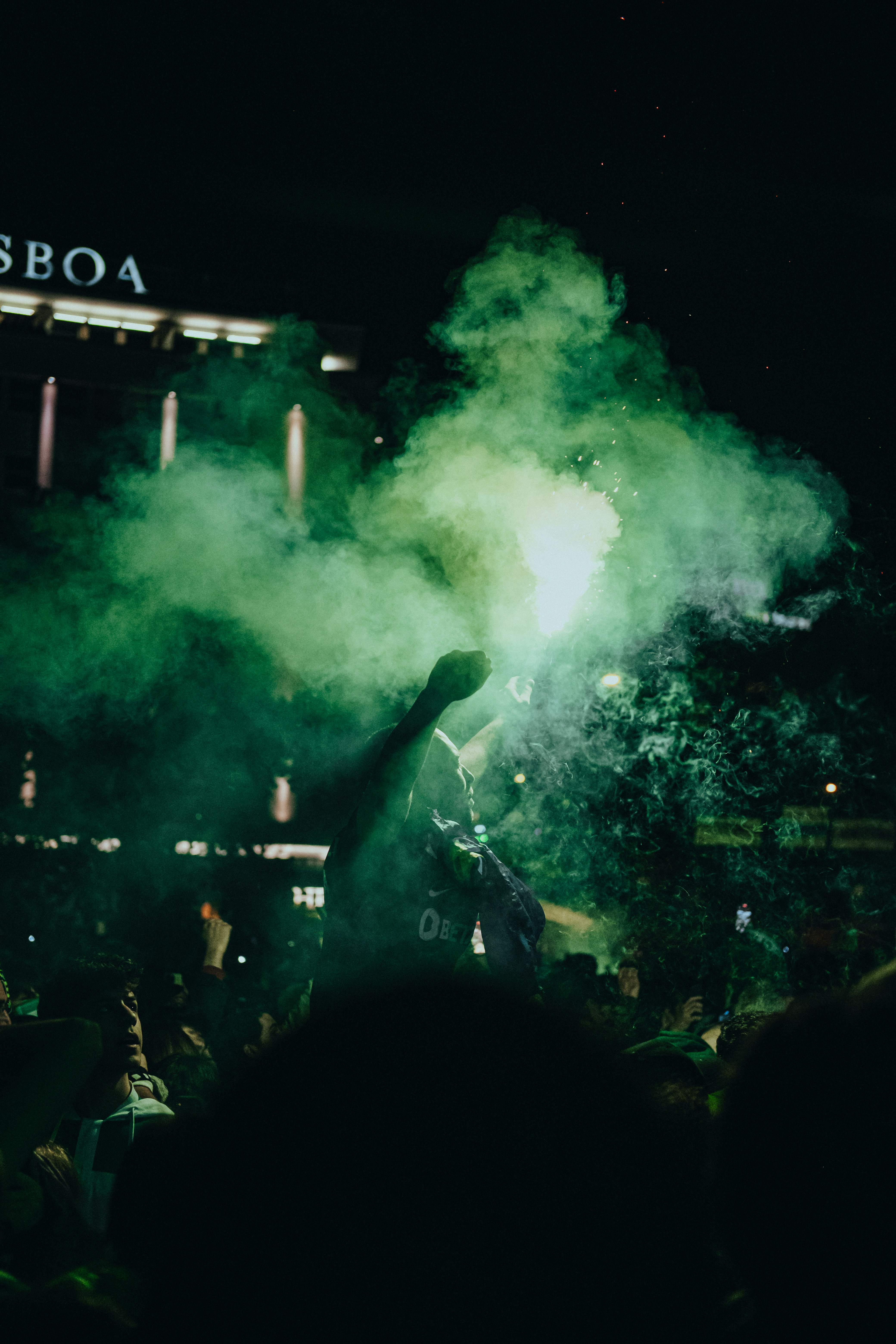 Eine Menschenmenge, die um eine grüne Rauchbombe herum steht