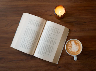 A cup of coffee and an open book on a table