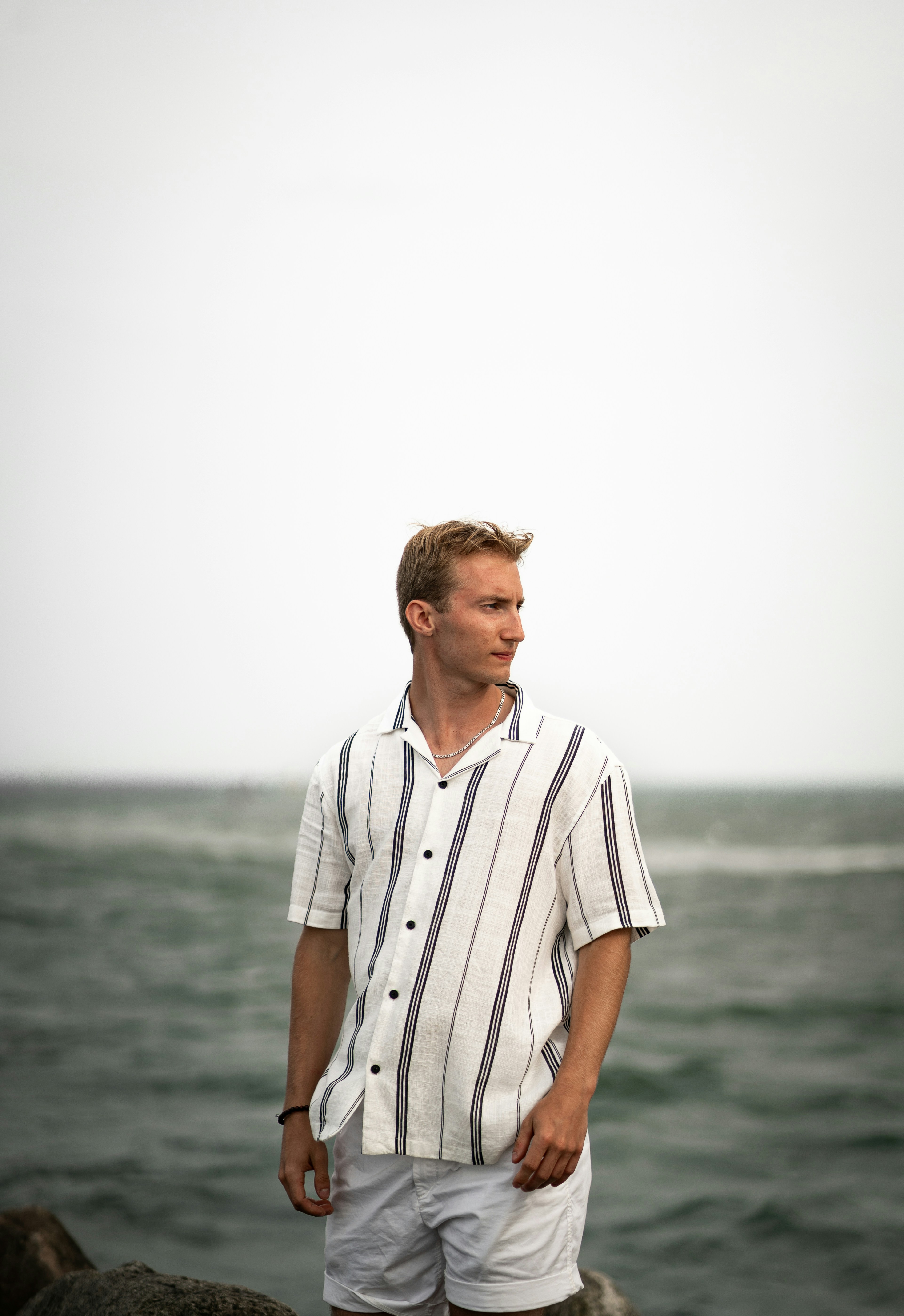 A man standing on a rock near the ocean