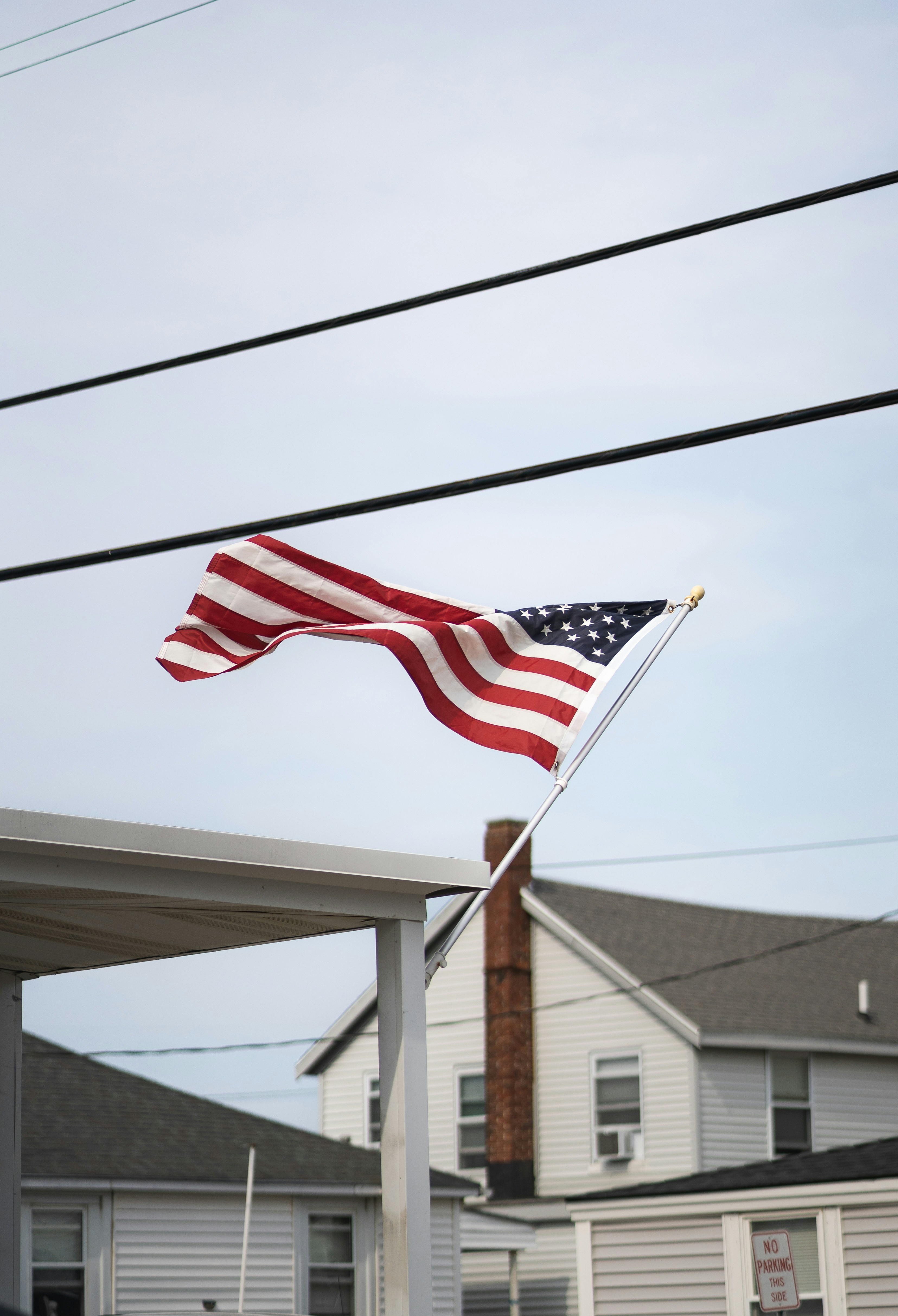 An american flag on a pole in front of a house
