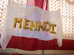 A sign that says mehndi hanging from a ceiling