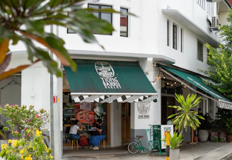A street corner with a store front and green awnings