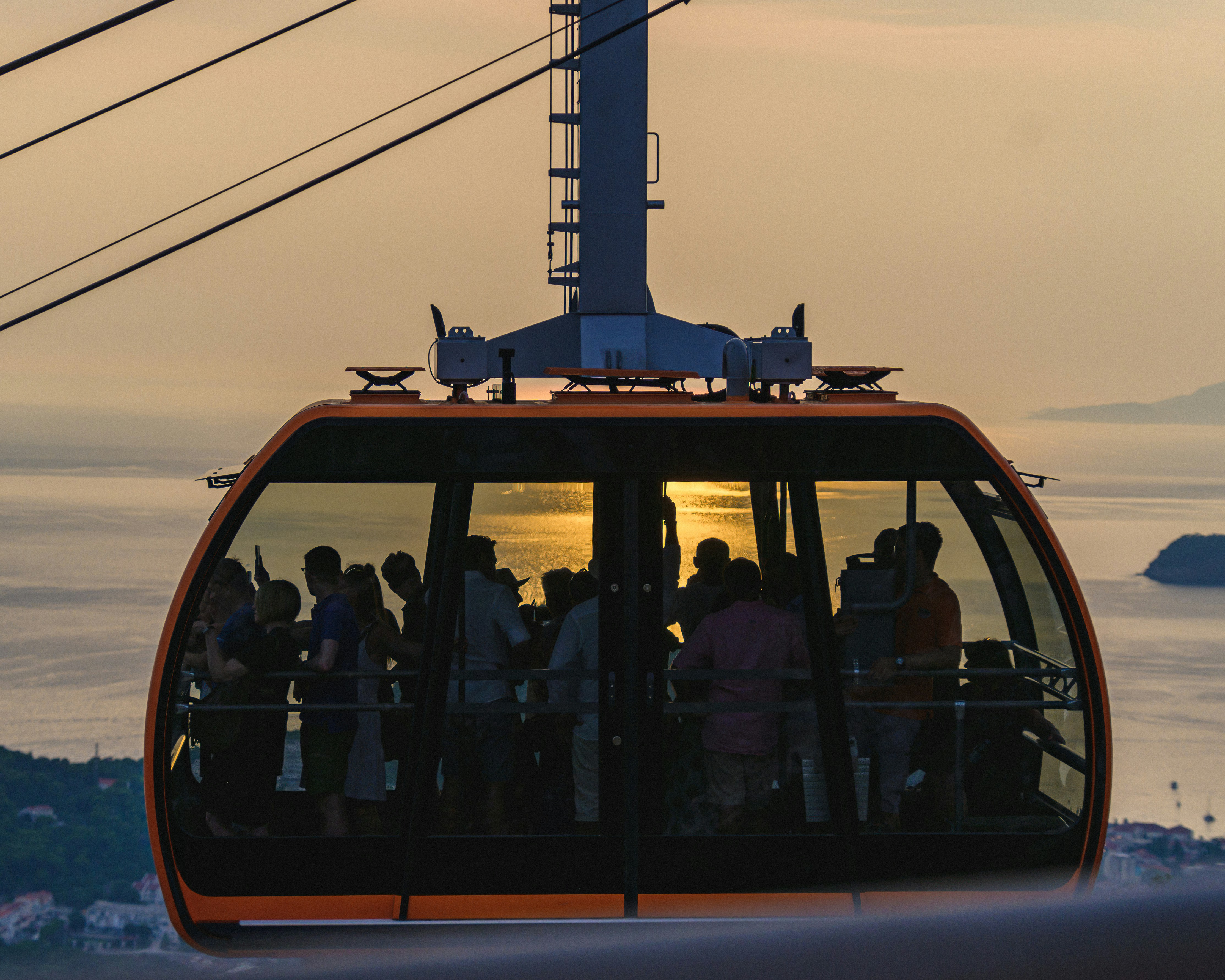 A group of people riding a cable car over a body of water