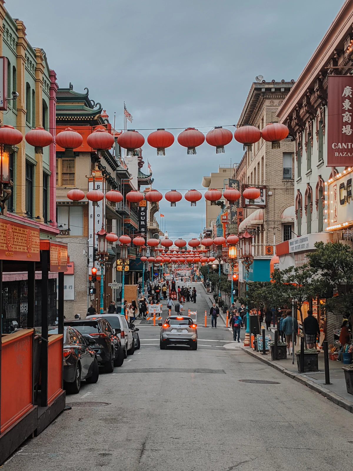 A Chinatown street descending beneath rows of red lanterns