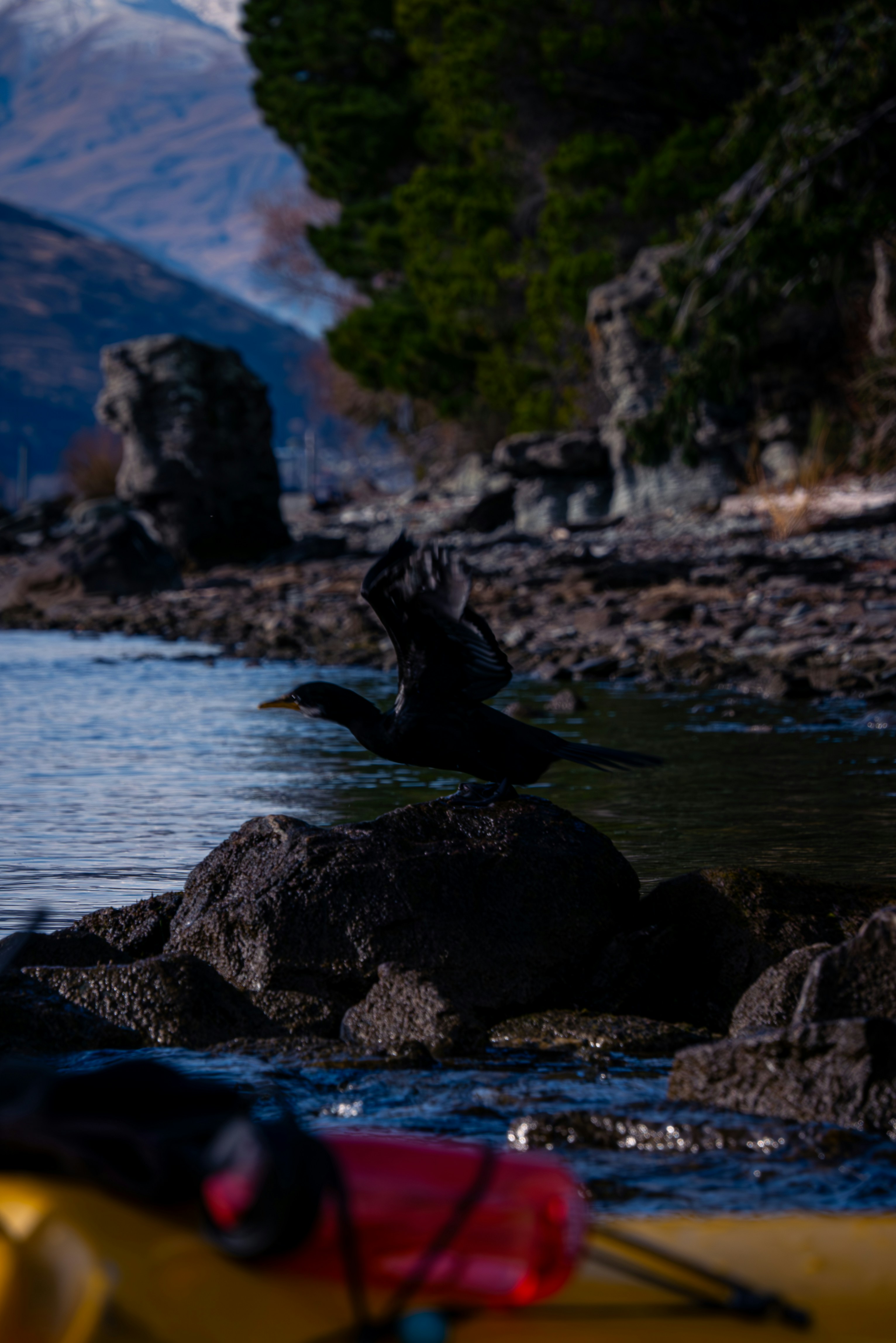 A yellow kayak sitting on the shore of a lake