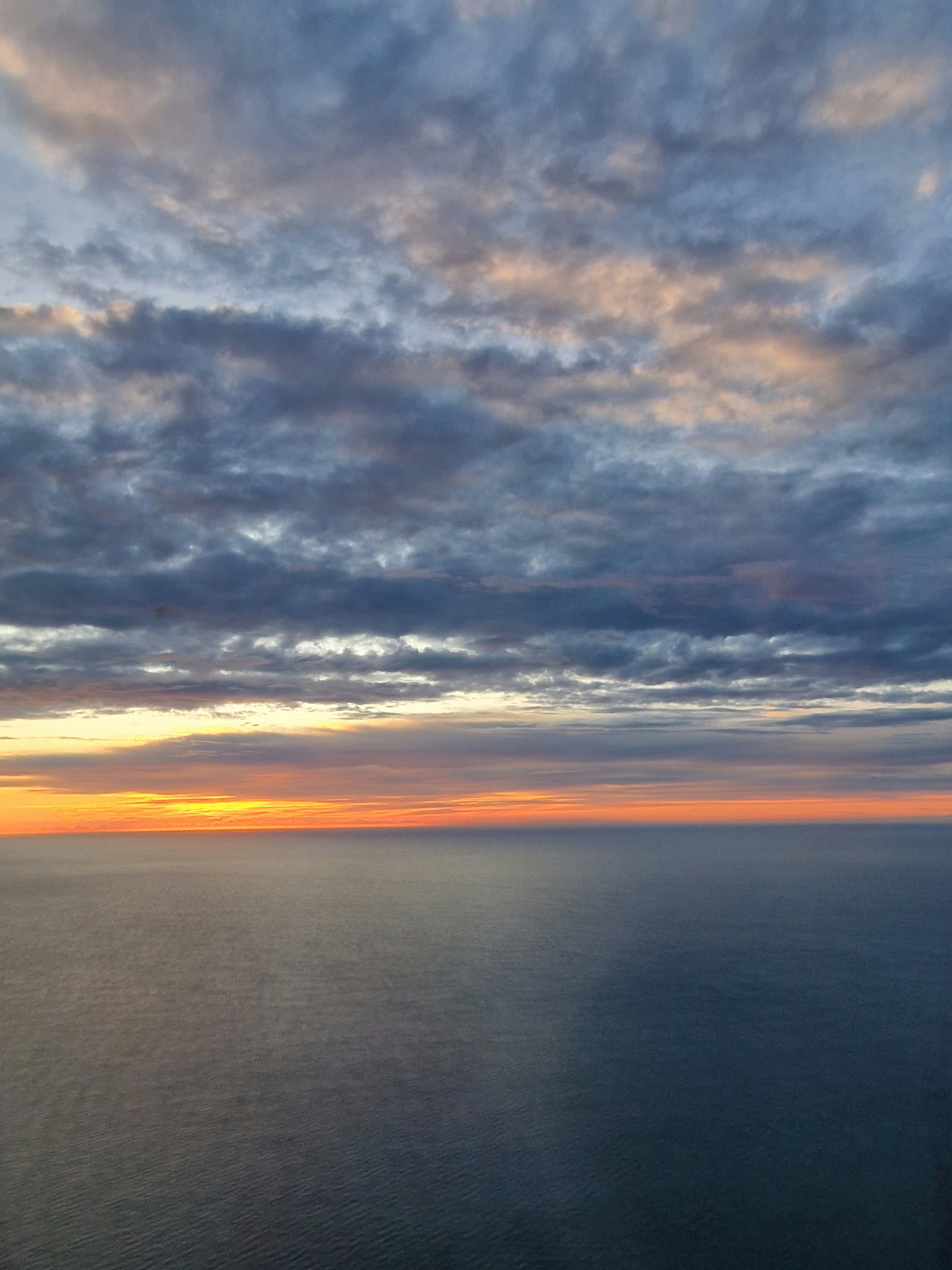 A view of the ocean at sunset from a plane