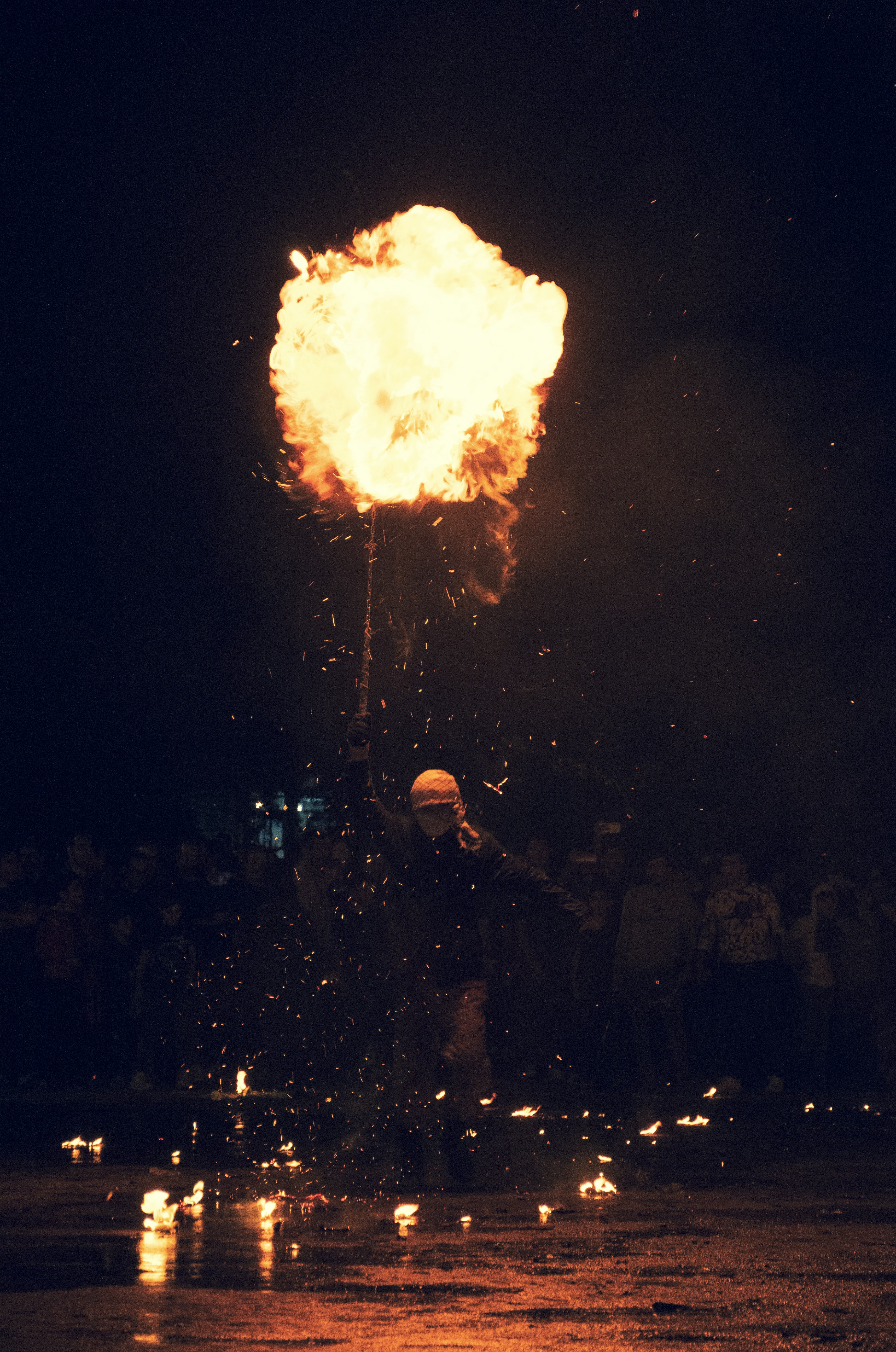 A person standing in front of a firework at night