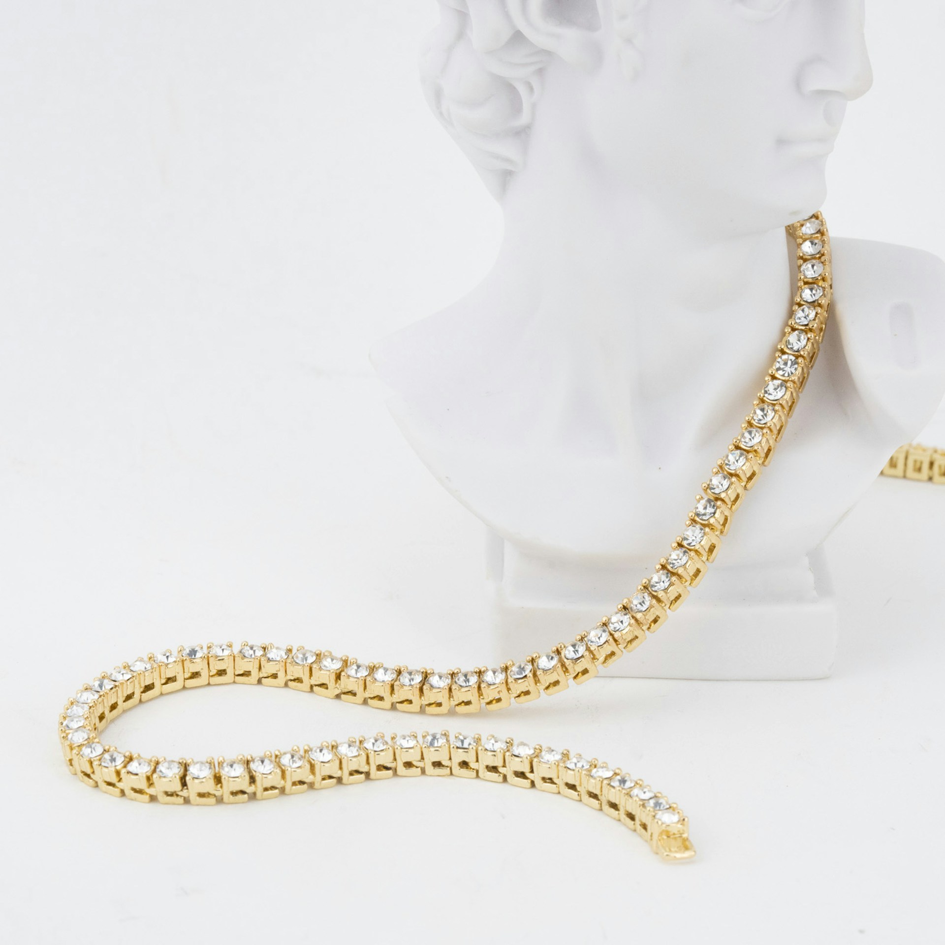 A white bust with a gold chain on it