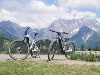 Two bikes parked next to each other in front of mountains