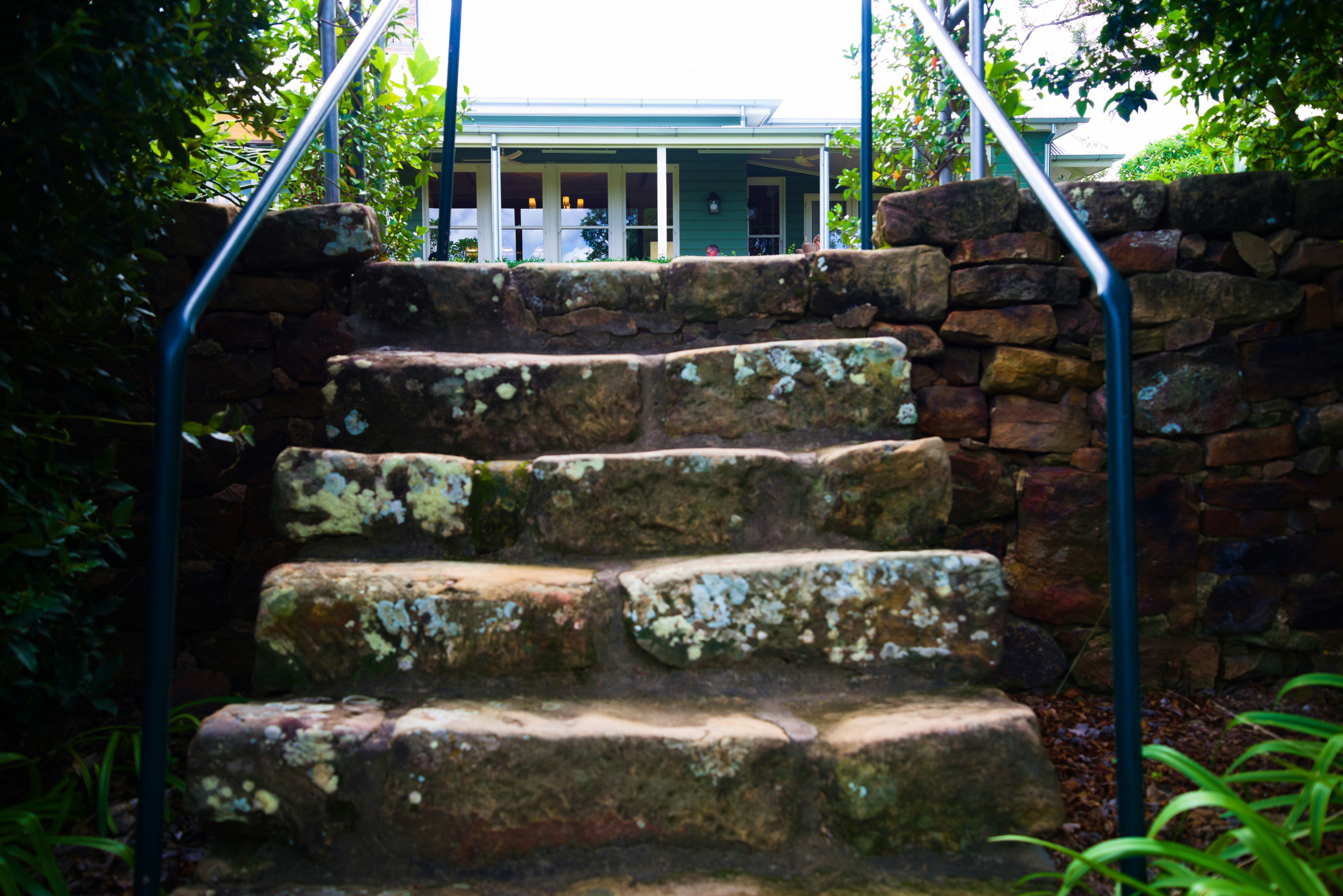 Beautiful Andover home entrance featuring stone walkway, granite steps, and integrated landscape lighting - Hardscaping Services Andover MA