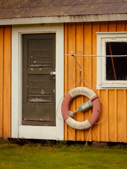 A yellow house with a life preserver hanging from the side