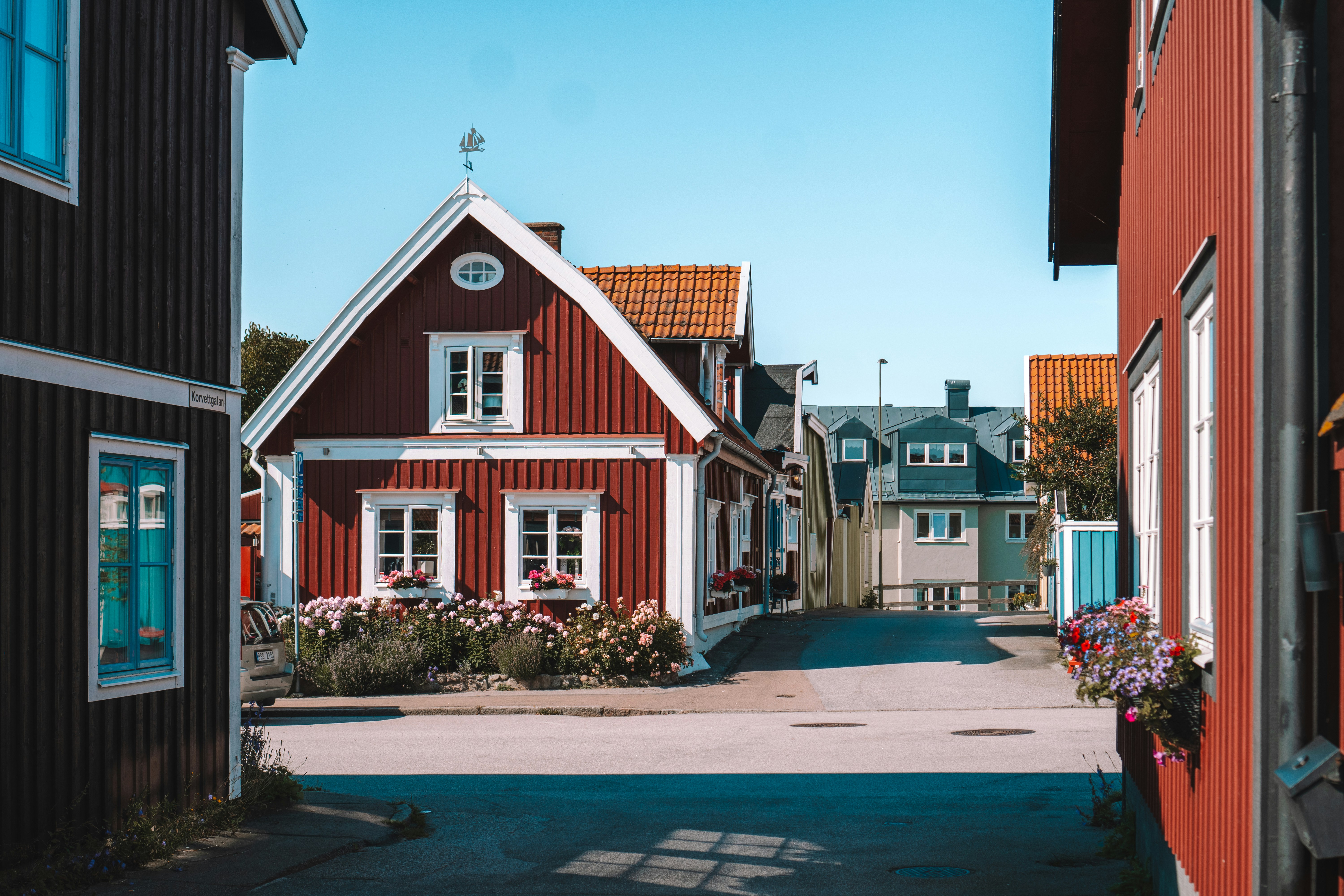 A narrow street with a red house on the side
