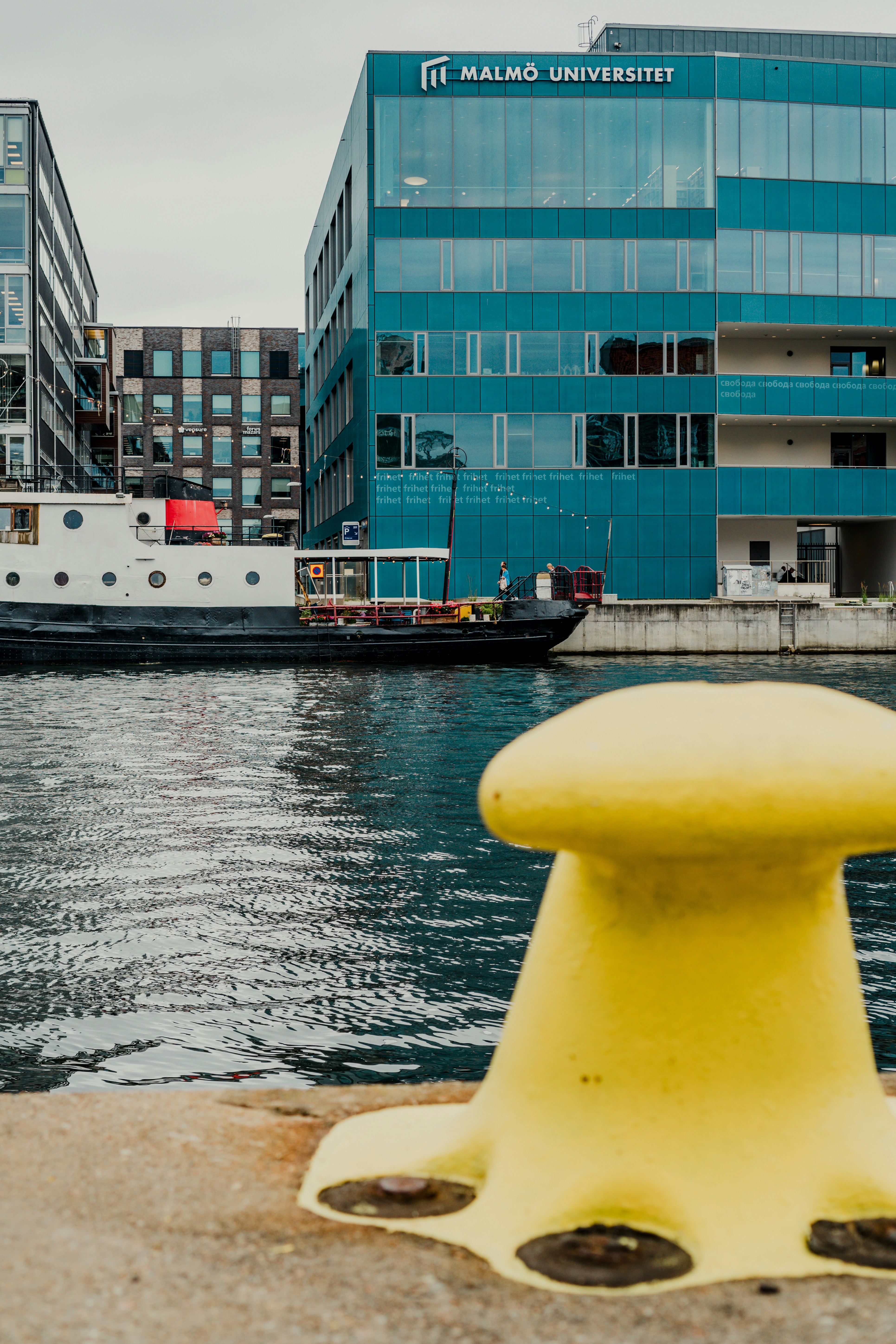 A yellow bench sitting in front of a body of water