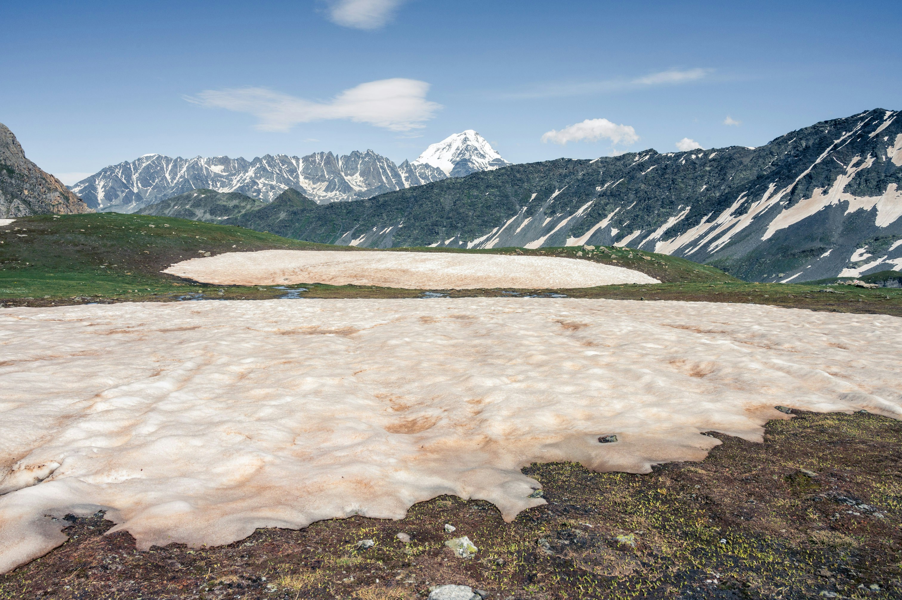 A snow covered field with mountains in the background