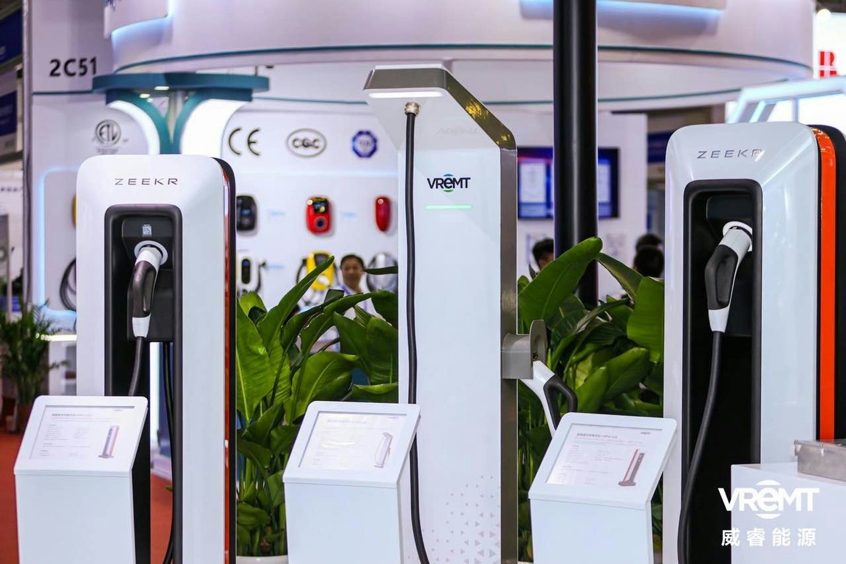 Row of modern electric cars plugged into public charging stations in a city.