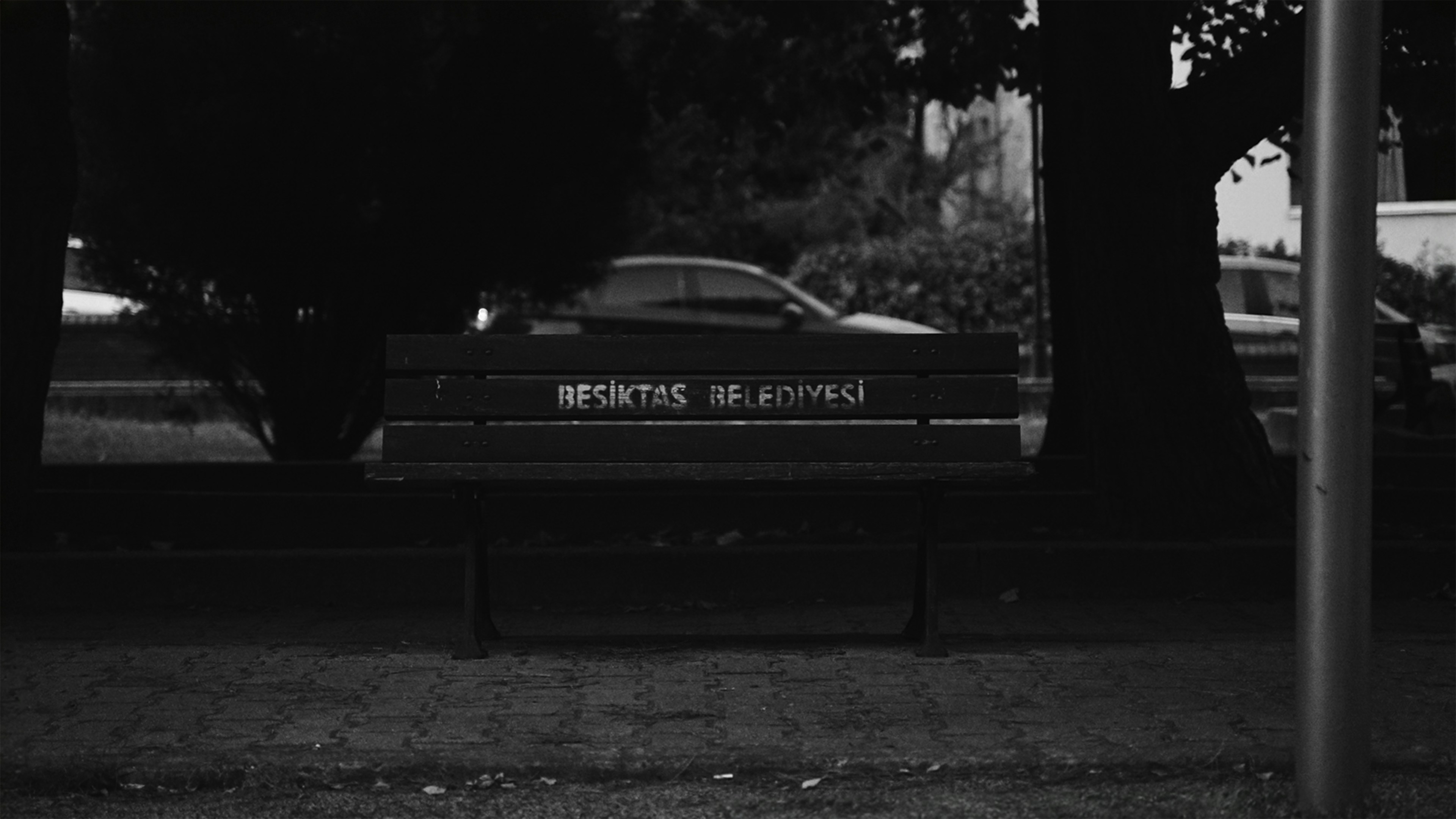 A black and white photo of a park bench