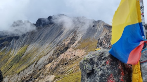 A flag on a rock with a mountain in the background