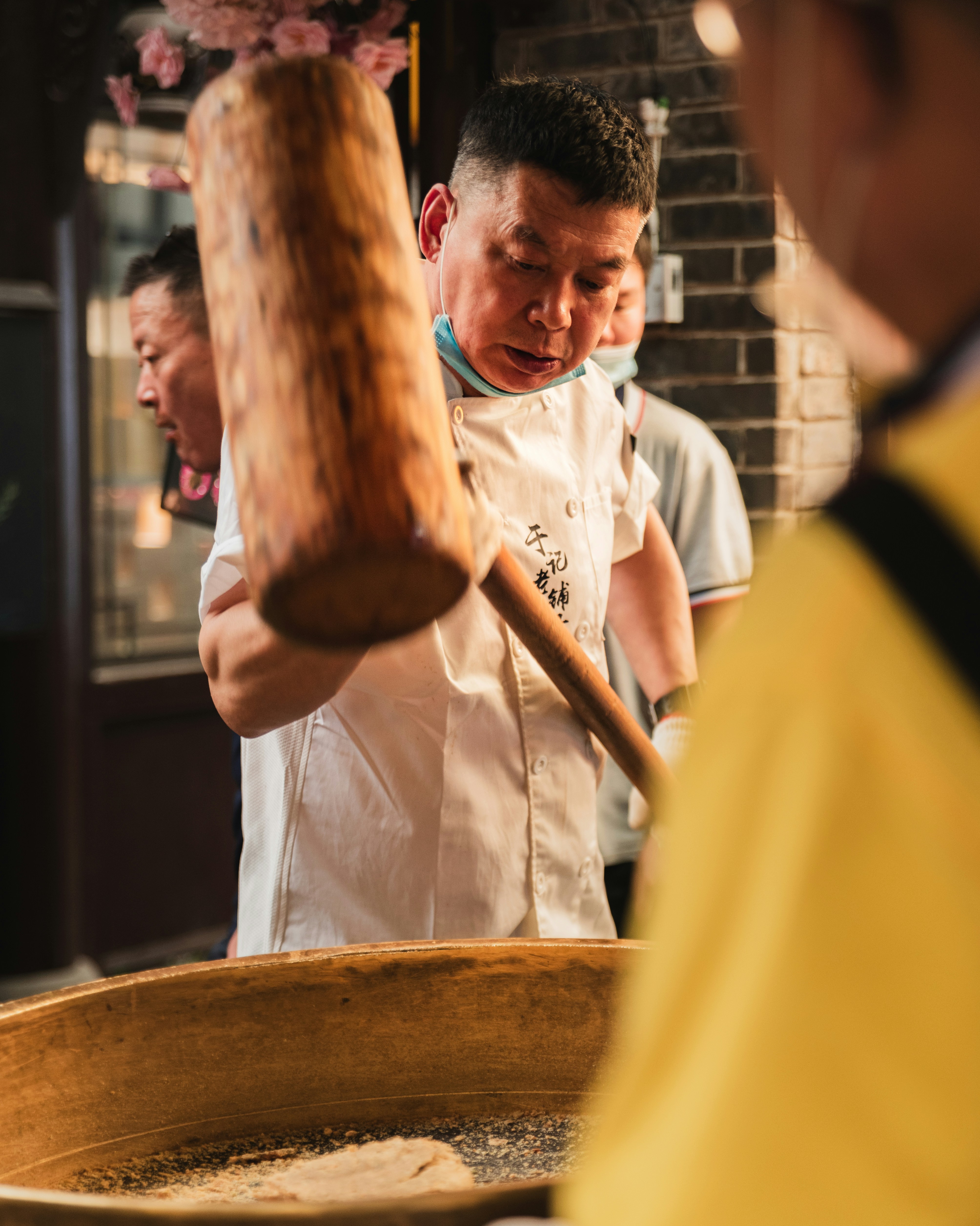 A group of men standing around a wooden bowl