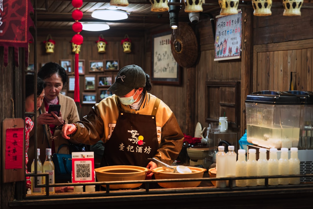 A man standing behind a counter in a restaurant,