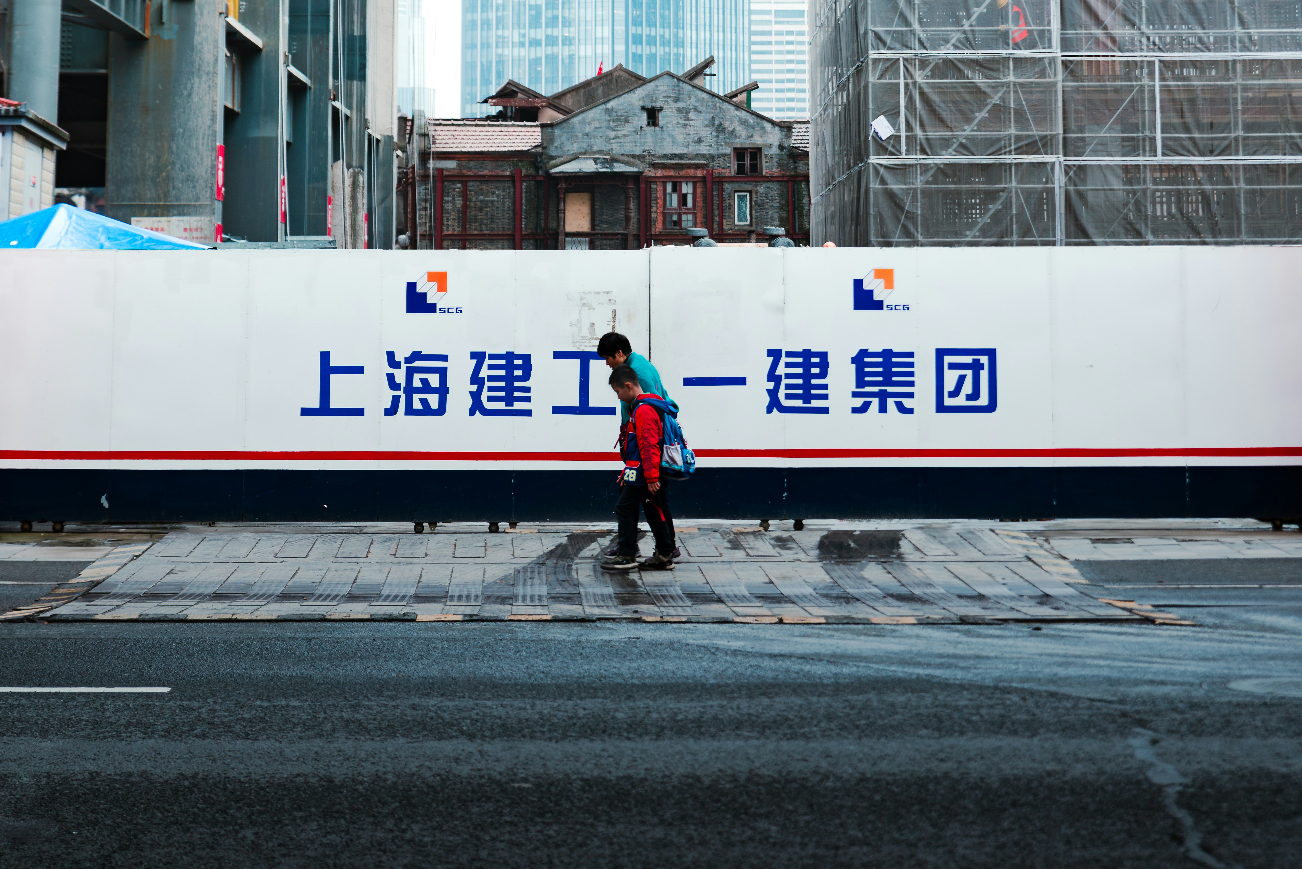 A woman crossing a street in front of a large billboard