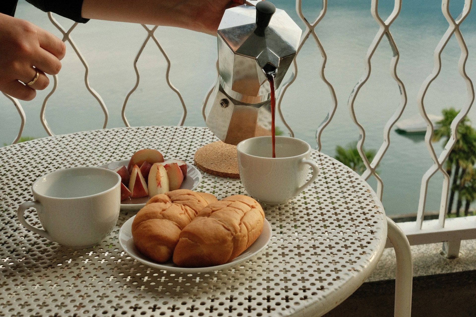 A person pours a cup of coffee over a plate of food