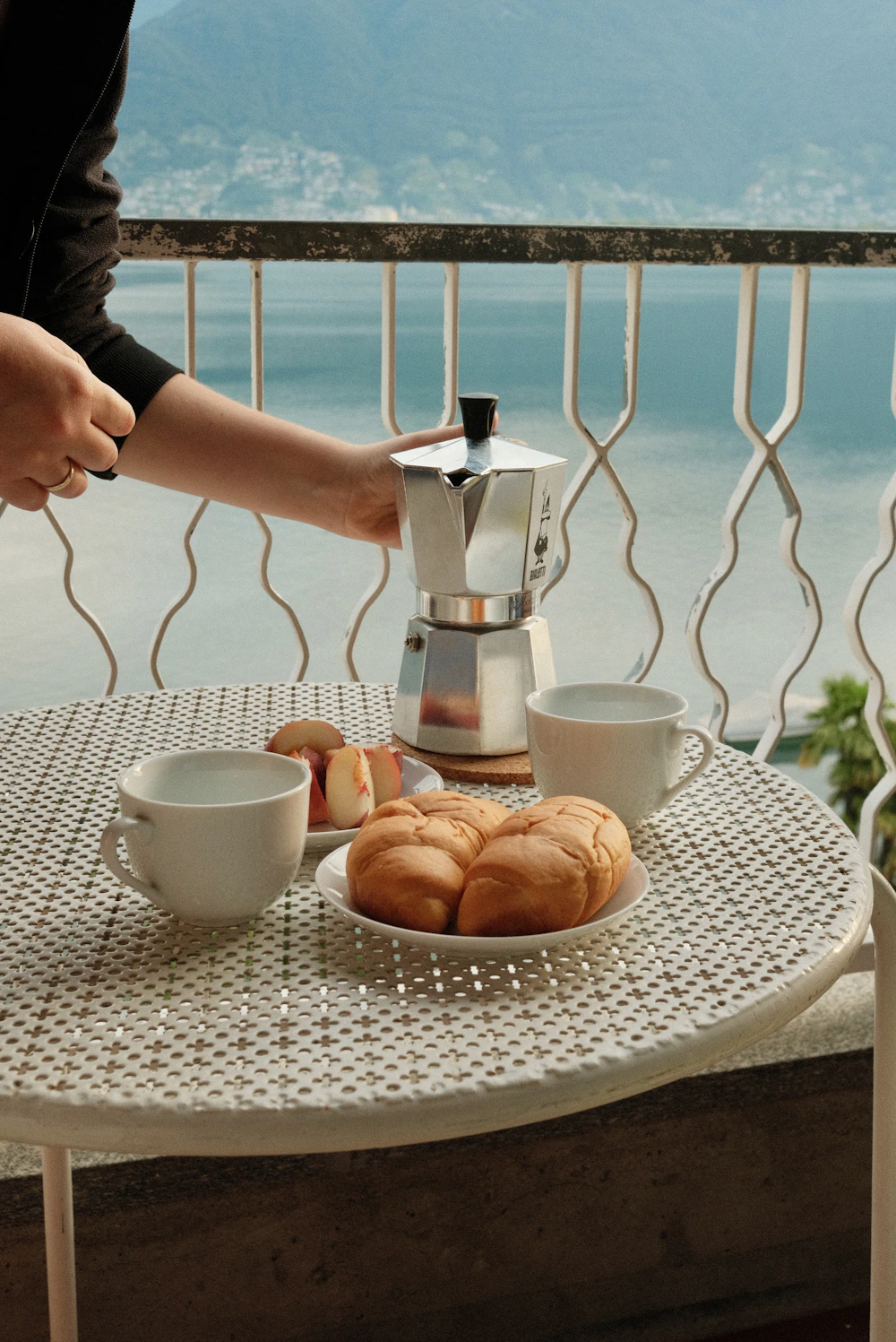 Fresh croissants and morning coffee arranged on a table overlooking a peaceful setting