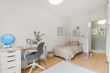A bedroom with two beds and a desk
