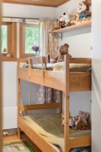 A bunk bed in a small room with stuffed animals