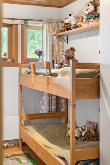 A bunk bed in a small room with stuffed animals