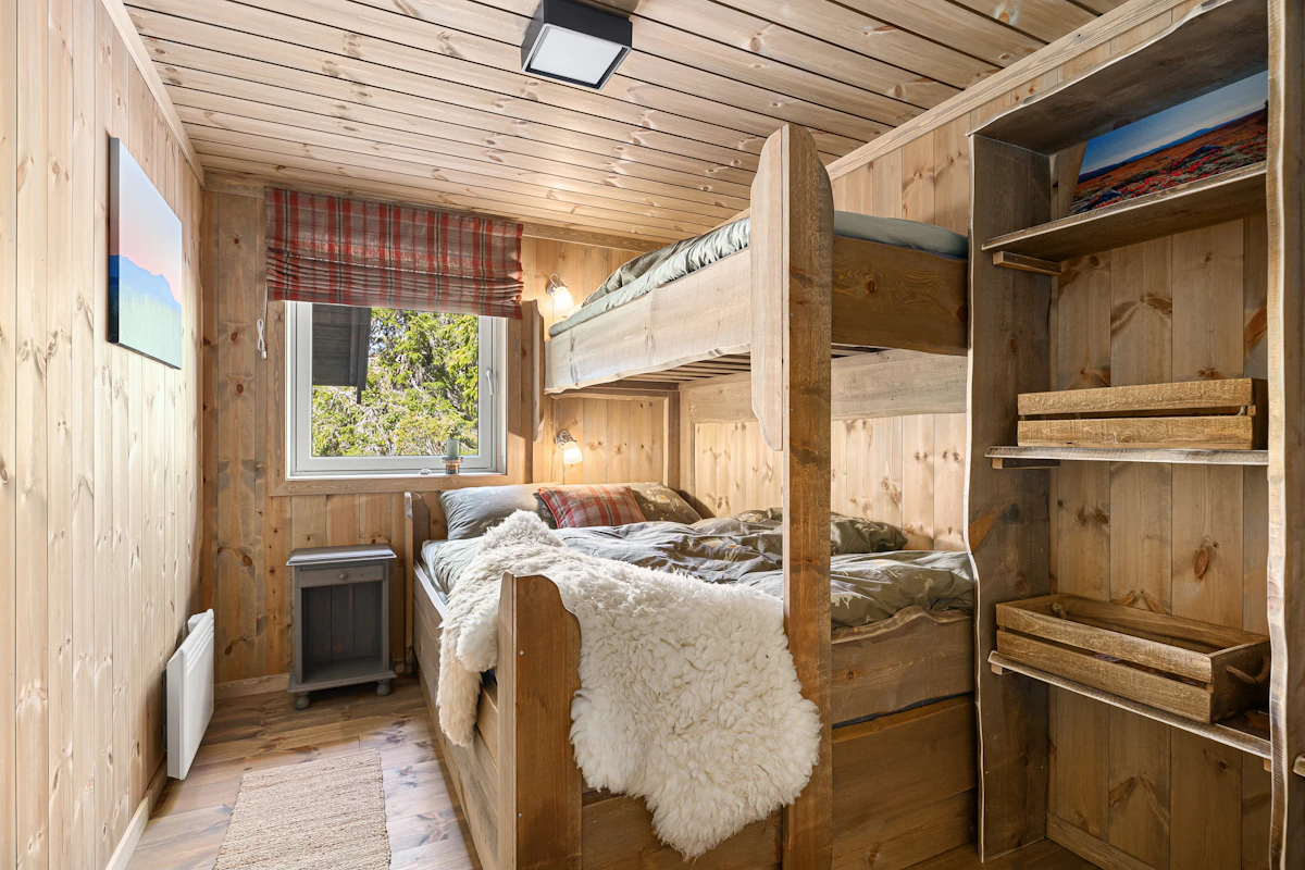 Habitación con literas de madera y estanterías