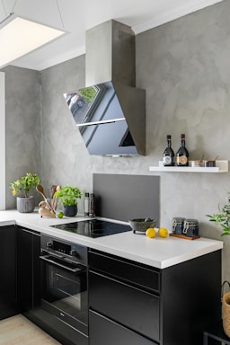 A kitchen with black cabinets and white counter tops