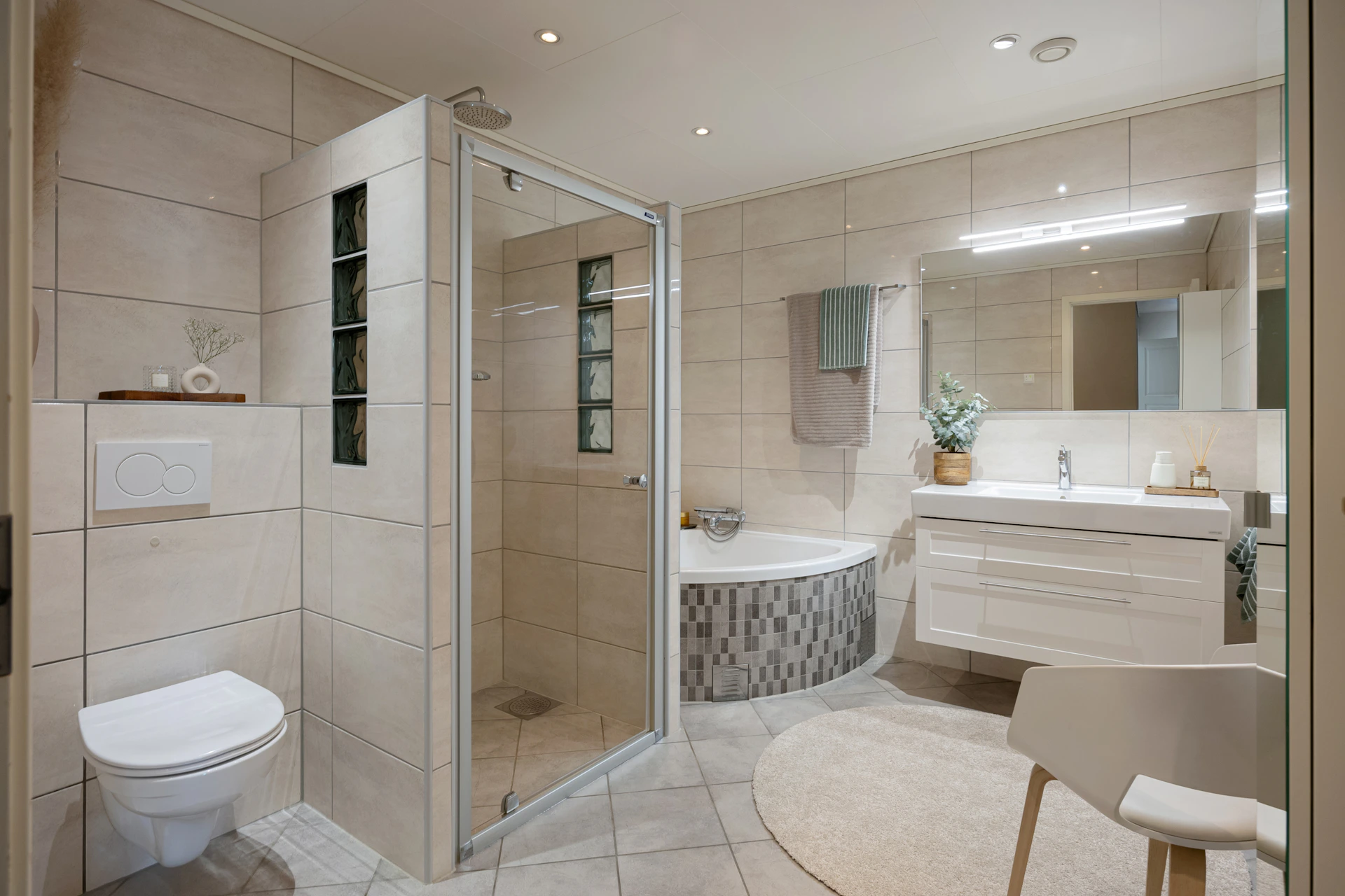 A large bathroom with a walk in shower next to a toilet