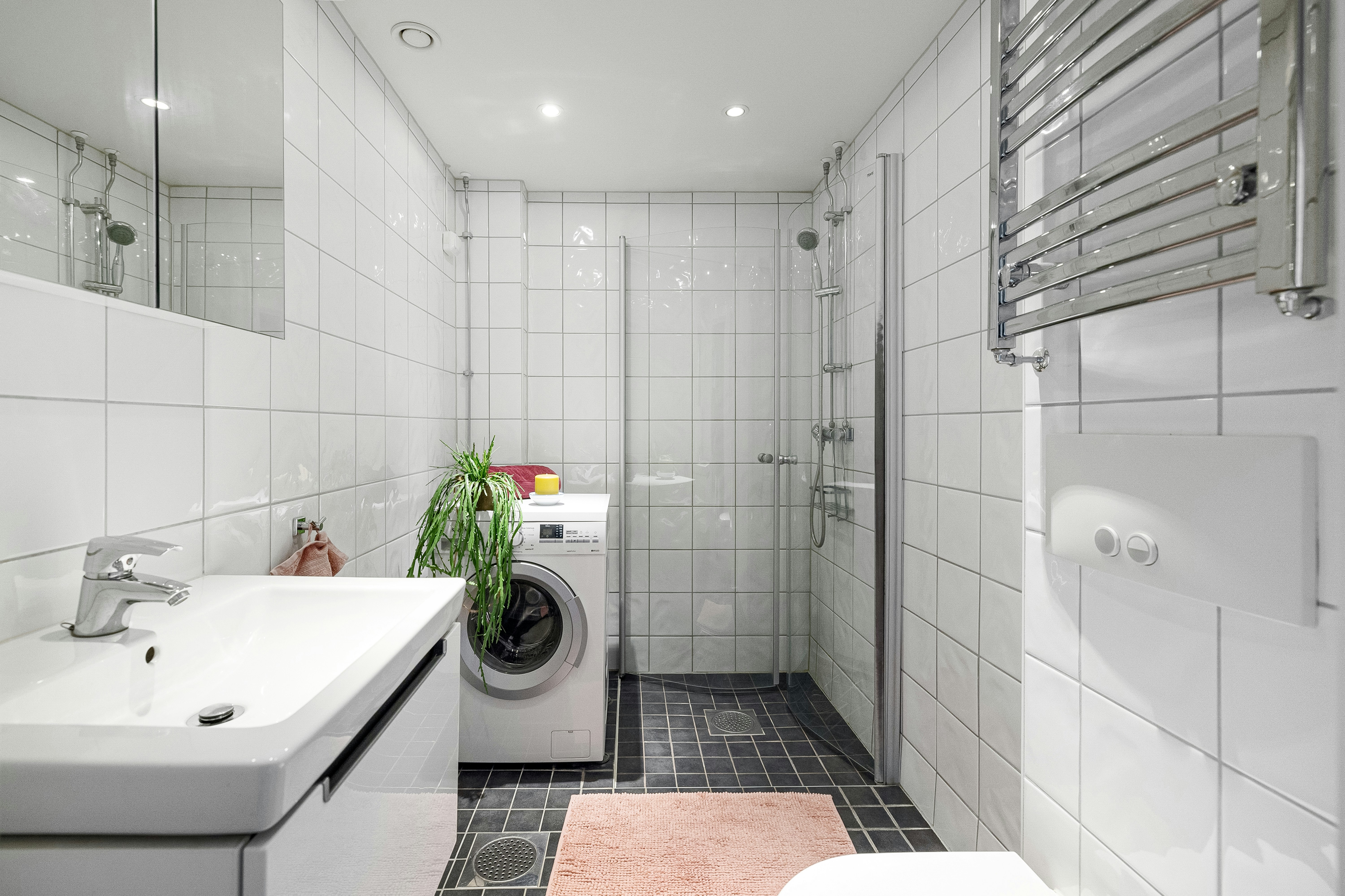 A bathroom with a toilet, sink, and washer