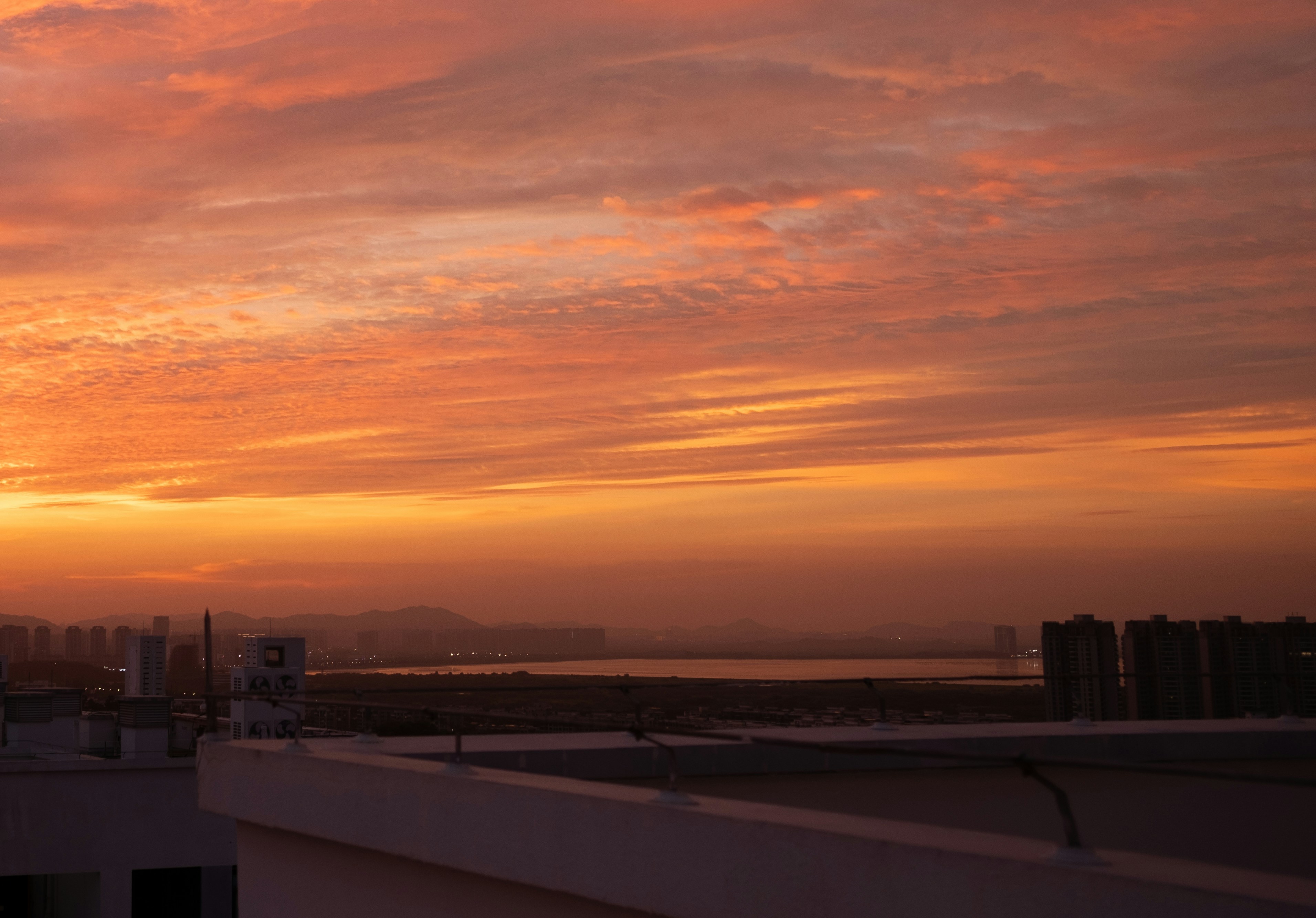 The sun is setting over a city with tall buildings