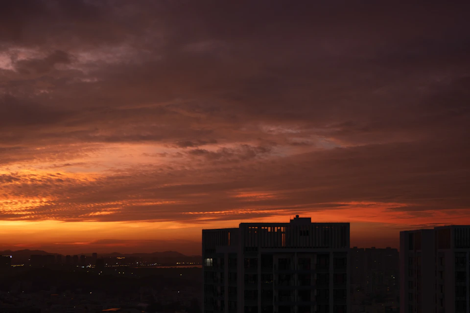 Cityscape at sunset with buildings and long shadows cast by setting sun