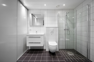 A bathroom with a toilet, sink, and shower