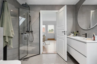 A large bathroom with a walk in shower next to a sink