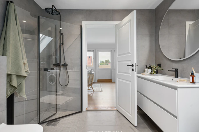 A large bathroom with a walk in shower next to a sink