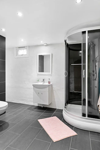 A large bathroom with a walk in shower next to a sink